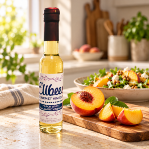 Ellbee’s Peach White Balsamic Vinegar bottle with serving suggestions on a kitchen countertop